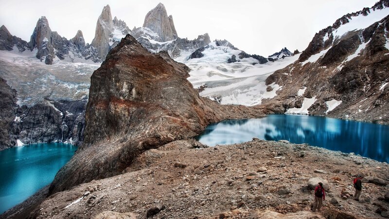 Hikers near a turquoise lake