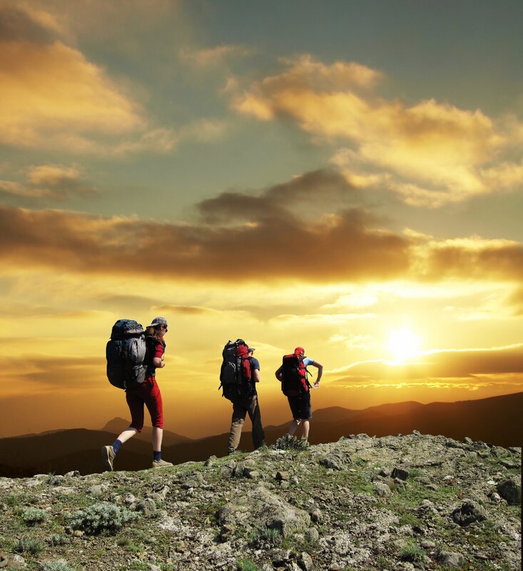 Hikers on a mountain at sunset