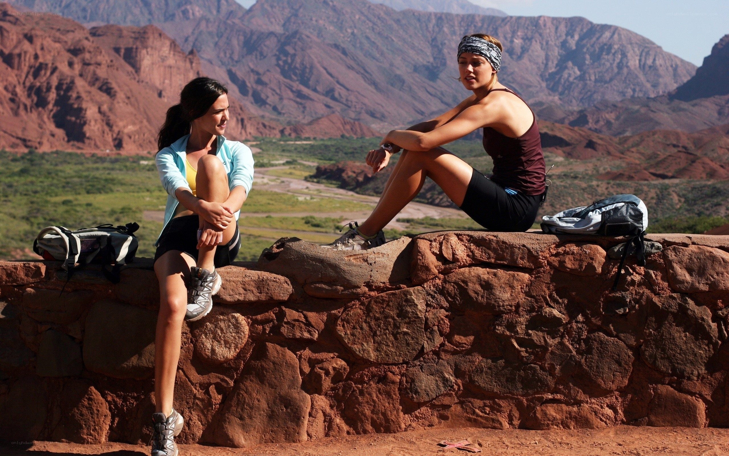 Hikers resting on a rock wall