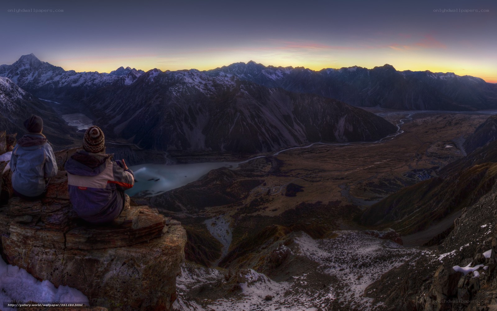 Hikers view mountain valley at dawn