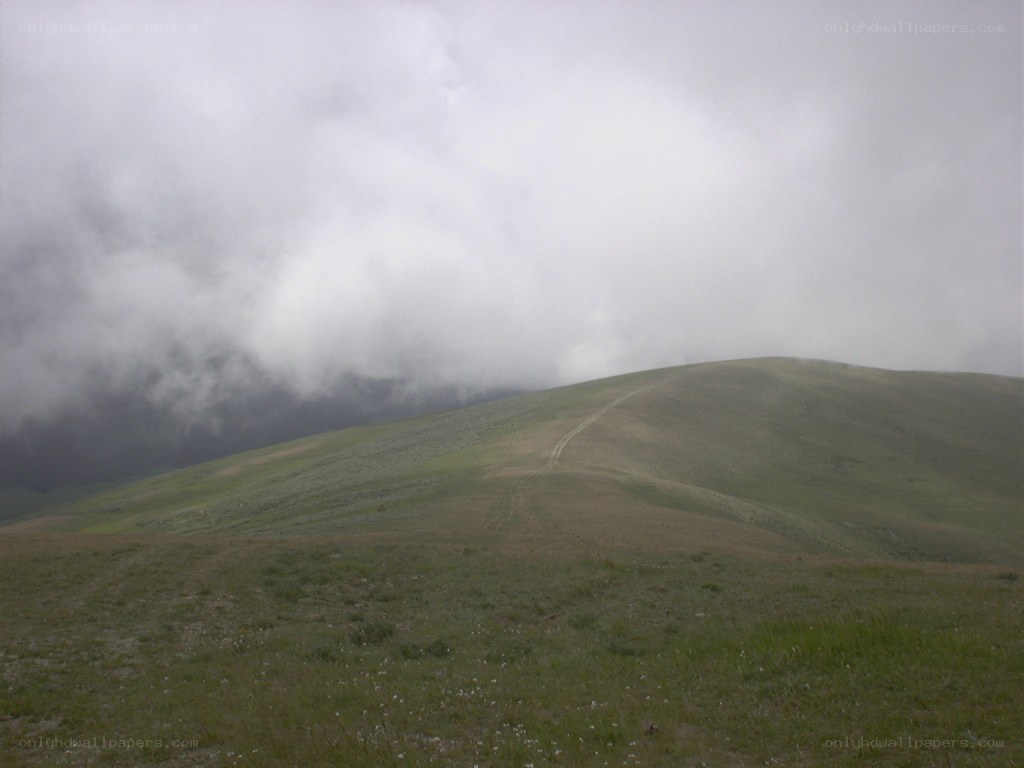 Hill under cloudy sky