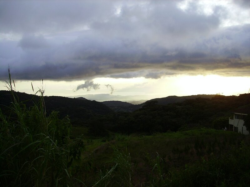 Hills under cloudy sky at sunset