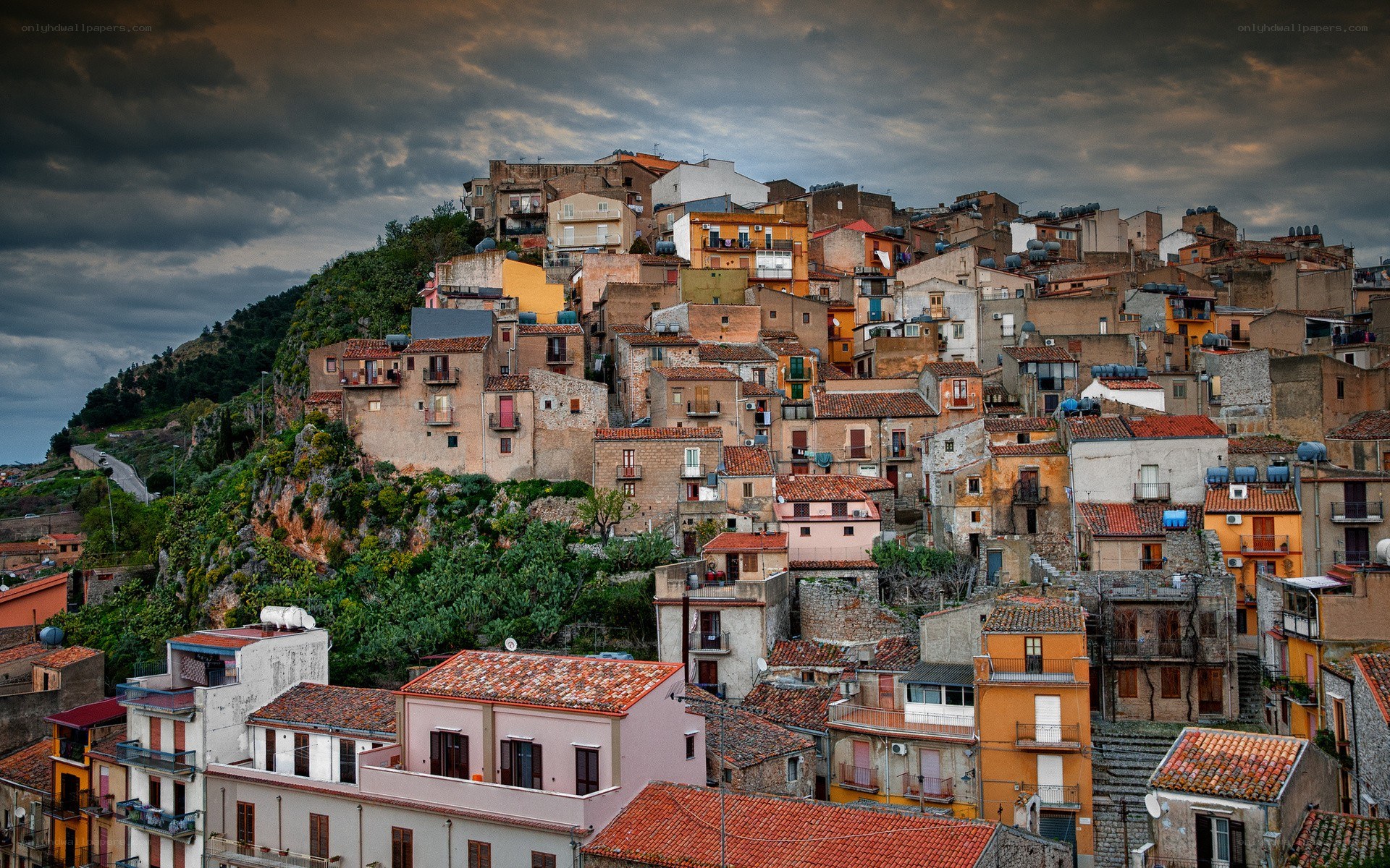 Hillside village under stormy sky