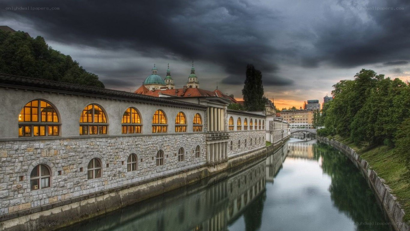 Historic building by a river at dusk