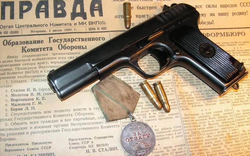 Historic firearm and medal on newspaper