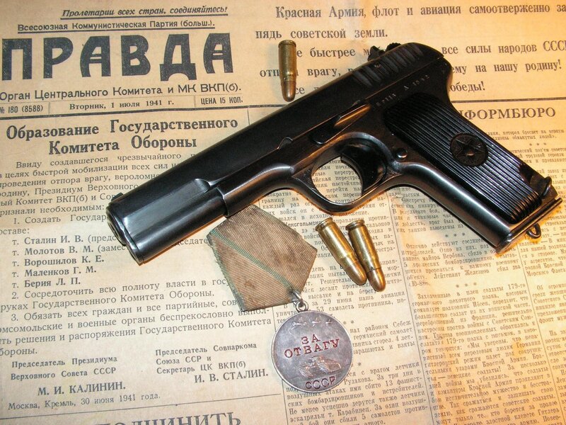 Historic firearm and medal on newspaper