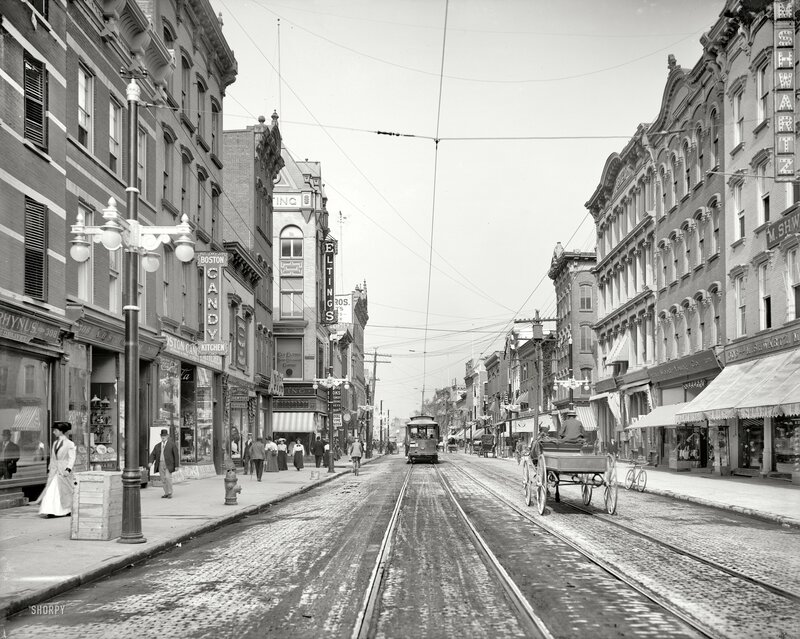 Historic street with trolley and horse-drawn carriage
