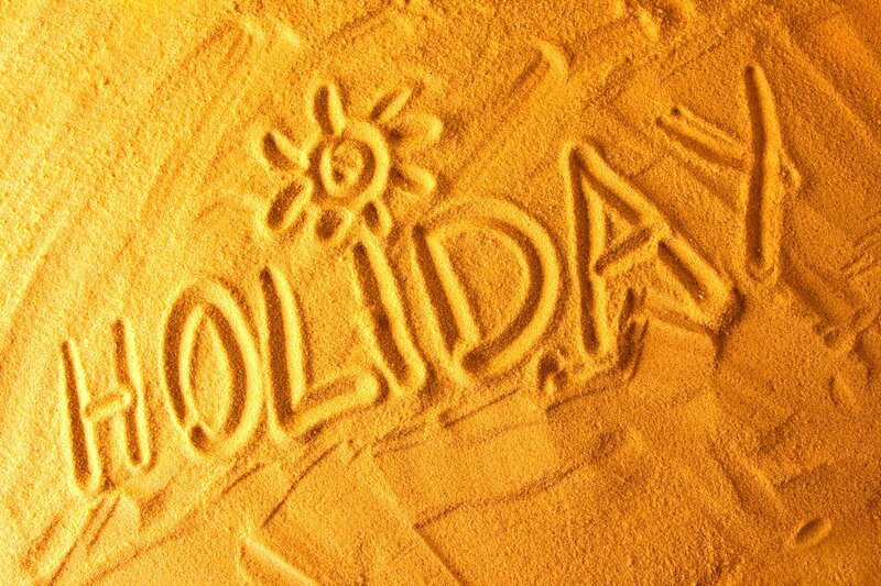 holiday written in sand