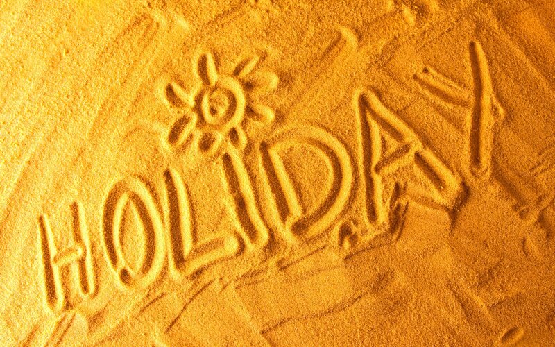 holiday written in sand