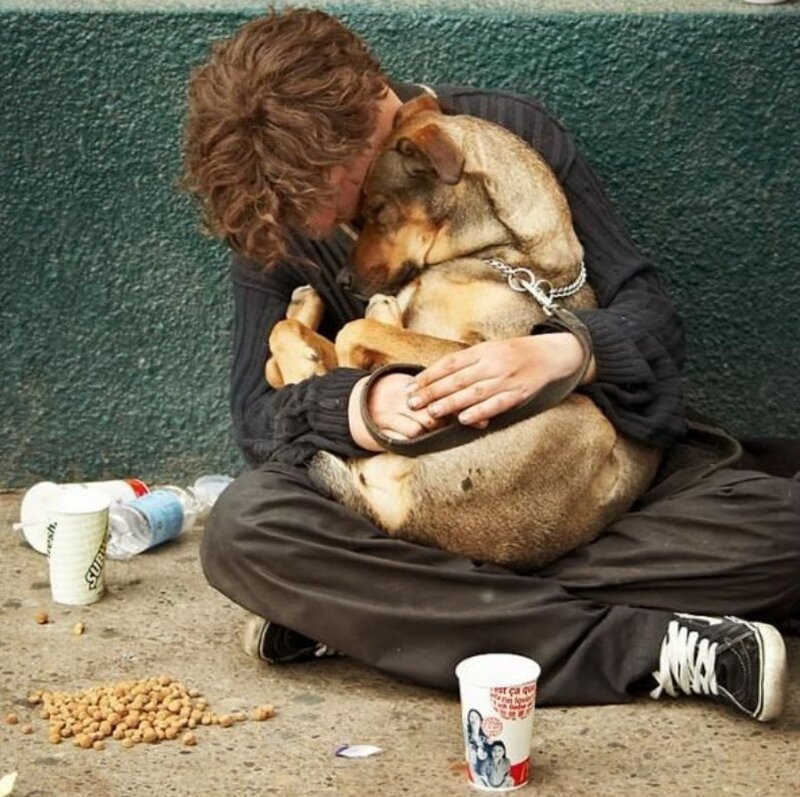 Homeless person hugging dog