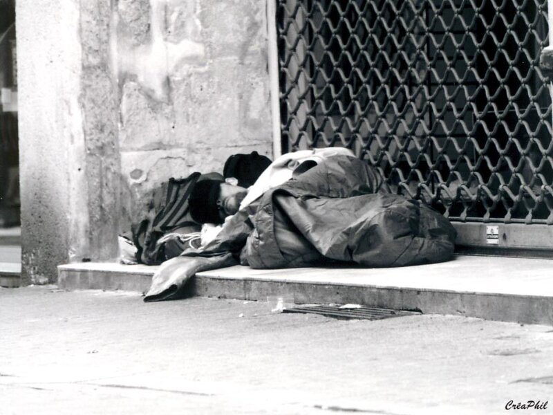 Homeless person sleeping on sidewalk