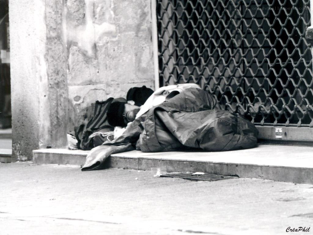 Homeless person sleeping on sidewalk