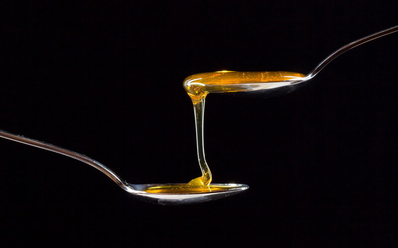 Honey Dripping Between Spoons
