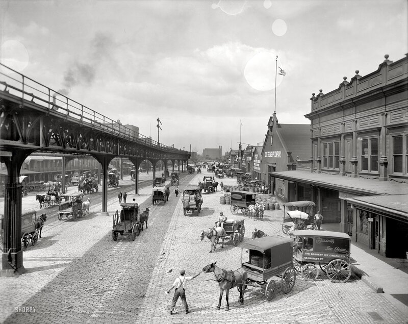Horse-drawn carts on a busy street