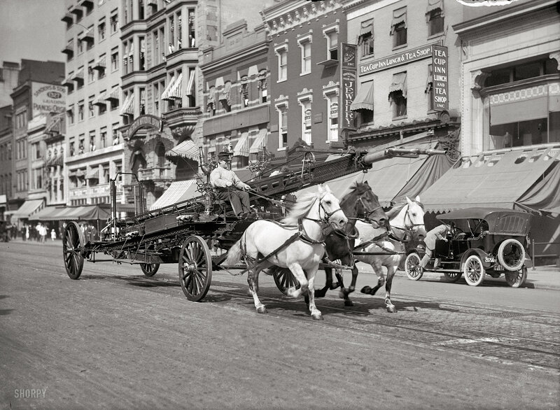 Horse-drawn fire engine on city street