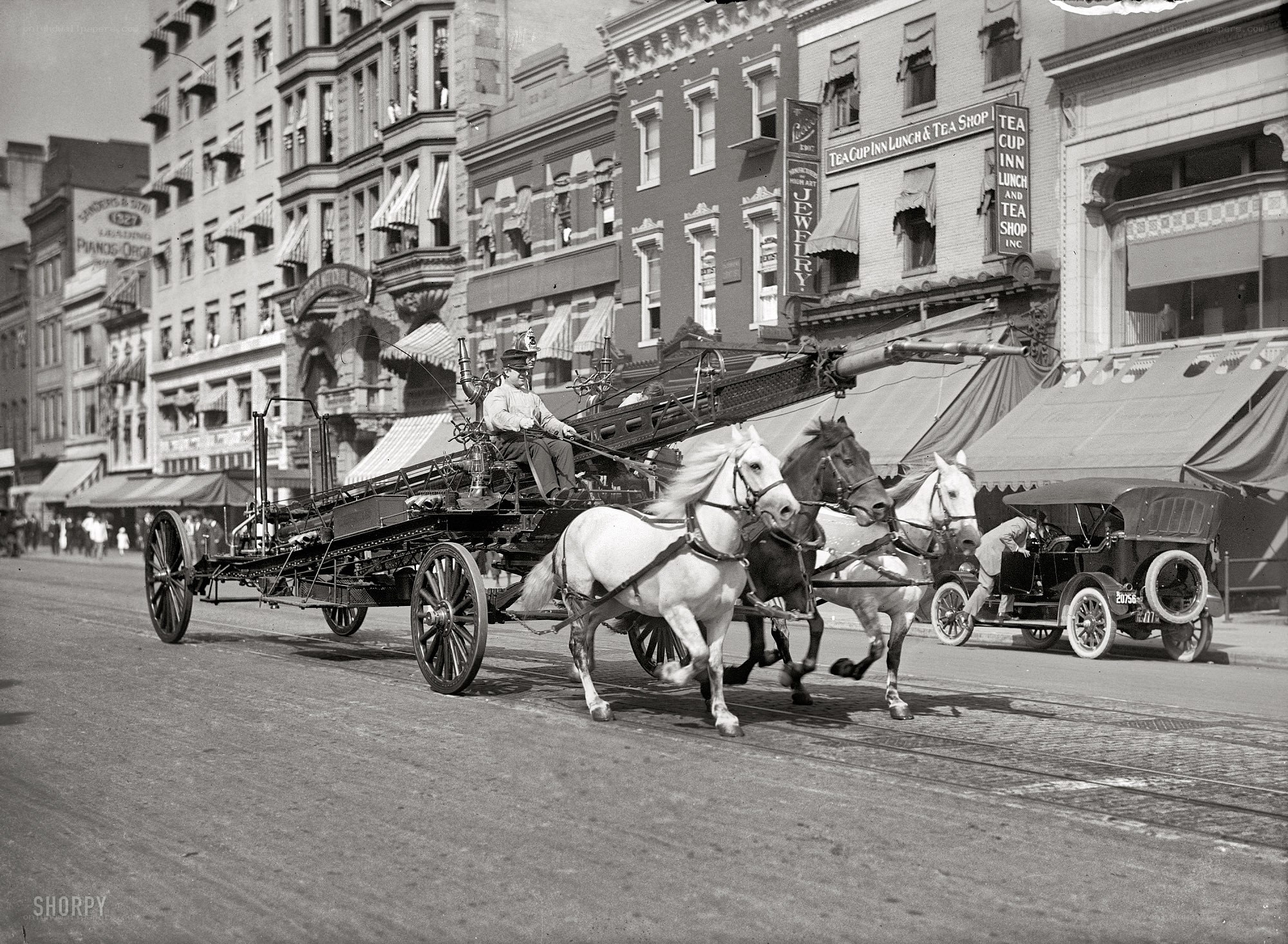 Horse-drawn fire engine on city street