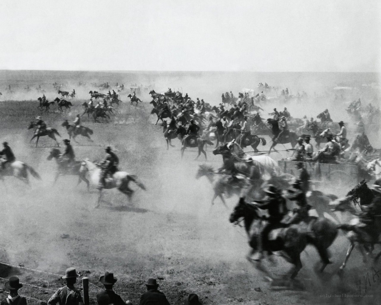 Horseback riders in a dusty field