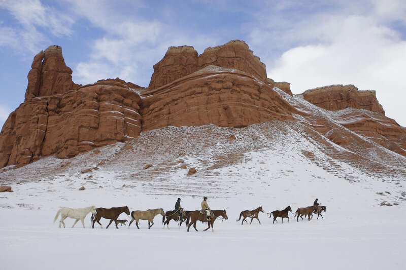 Horseback riders in snowy desert