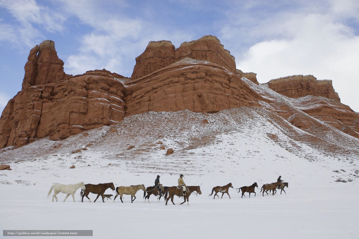 Horseback riders in snowy desert