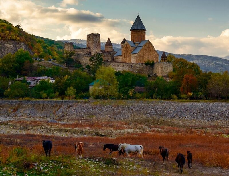 Horses graze near ancient monastery