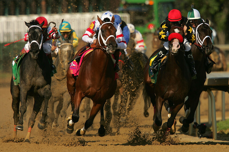 Horses racing on dirt track