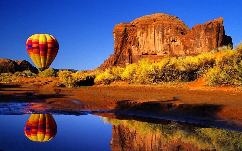 Hot Air Balloon in Desert — Blue, Serene, Morning, Photograph, Rock Formation, Puddle, Shrub