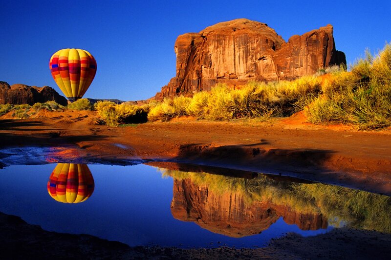 Hot air balloon over desert rock