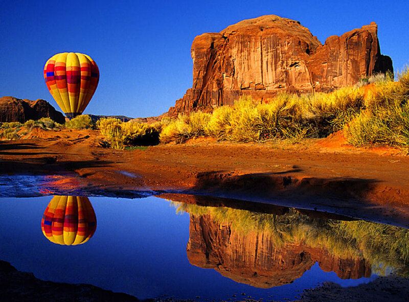 Hot air balloon over desert rock