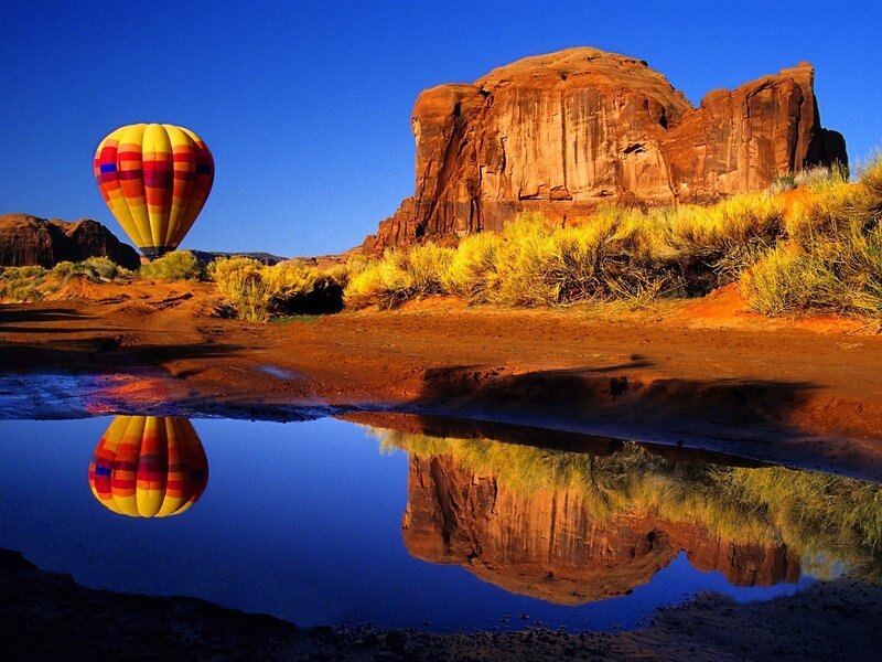 Hot air balloon over desert rock