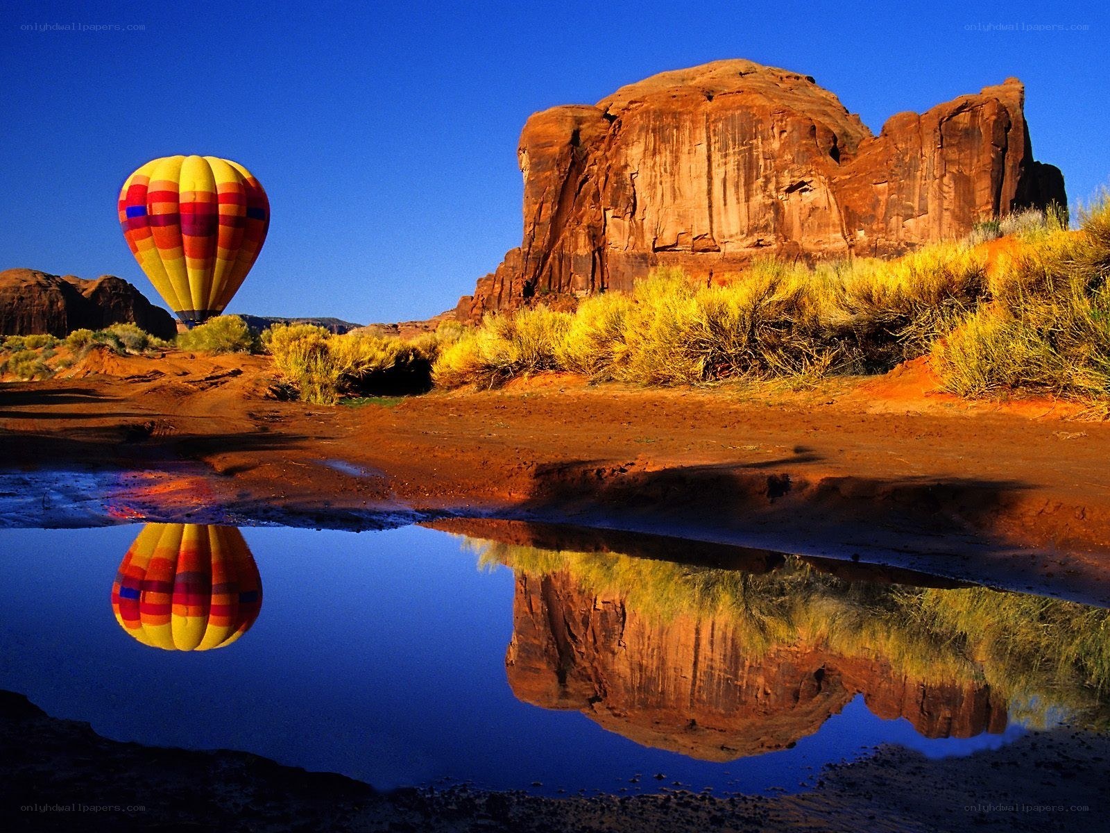 Hot air balloon over desert rock