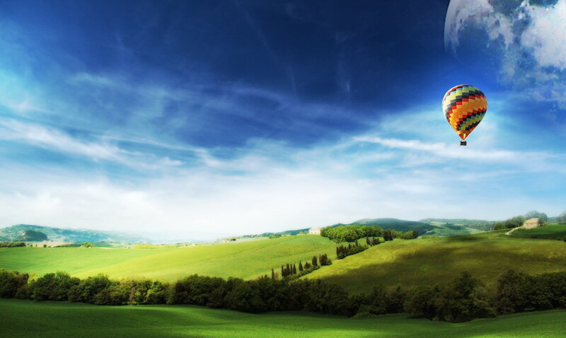 Hot air balloon over green hills