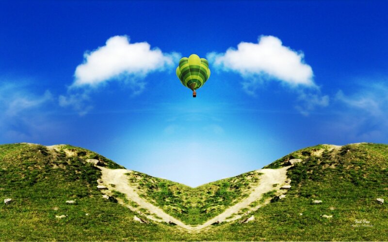 Hot air balloon over green hills