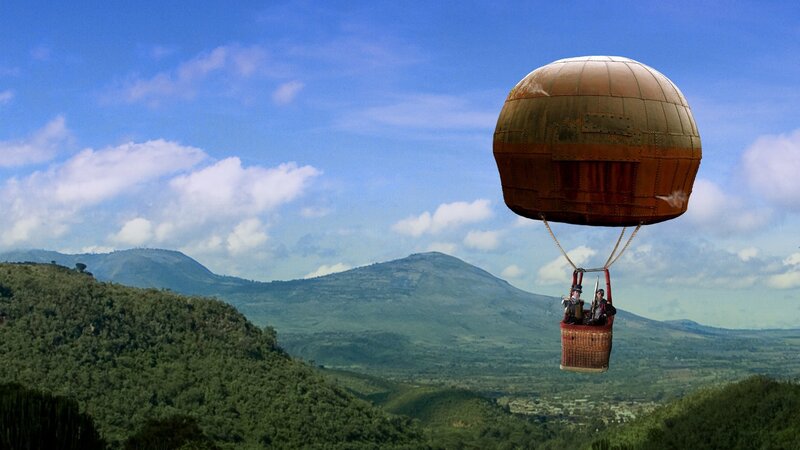 Hot air balloon over green hills