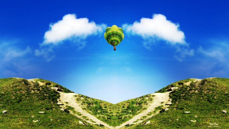 Hot air balloon over green hills