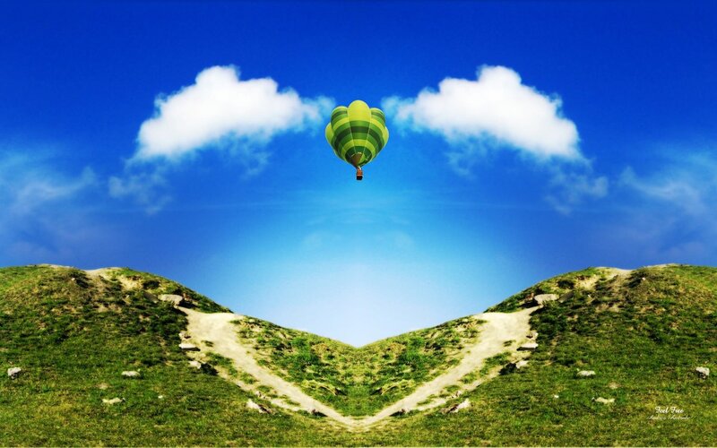 Hot air balloon over green hills