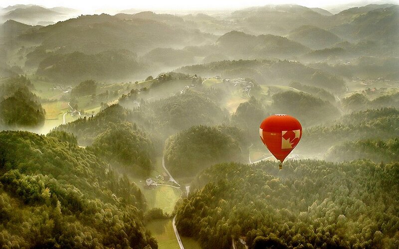 Hot air balloon over misty hills