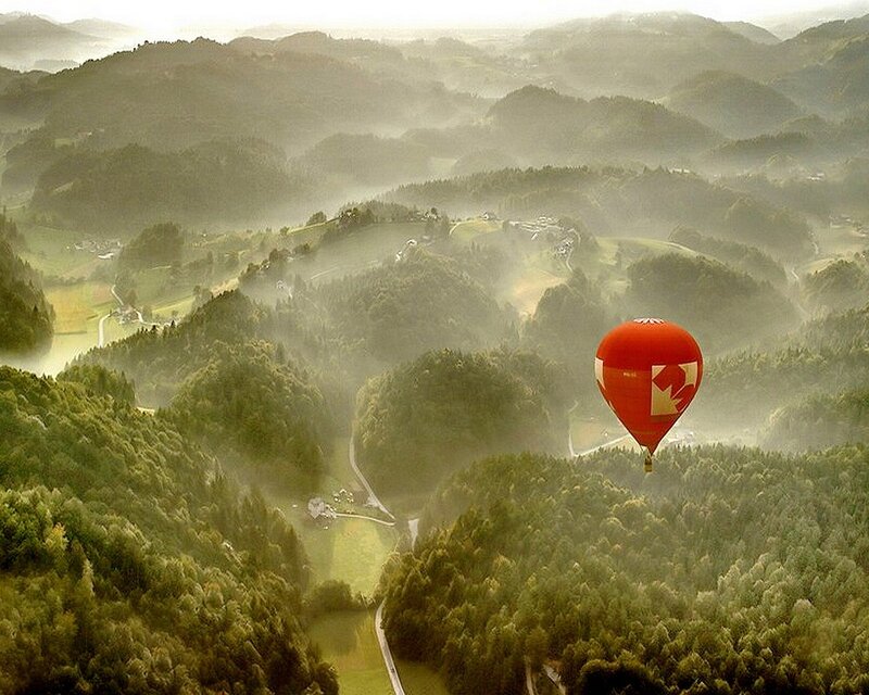 Hot air balloon over misty hills