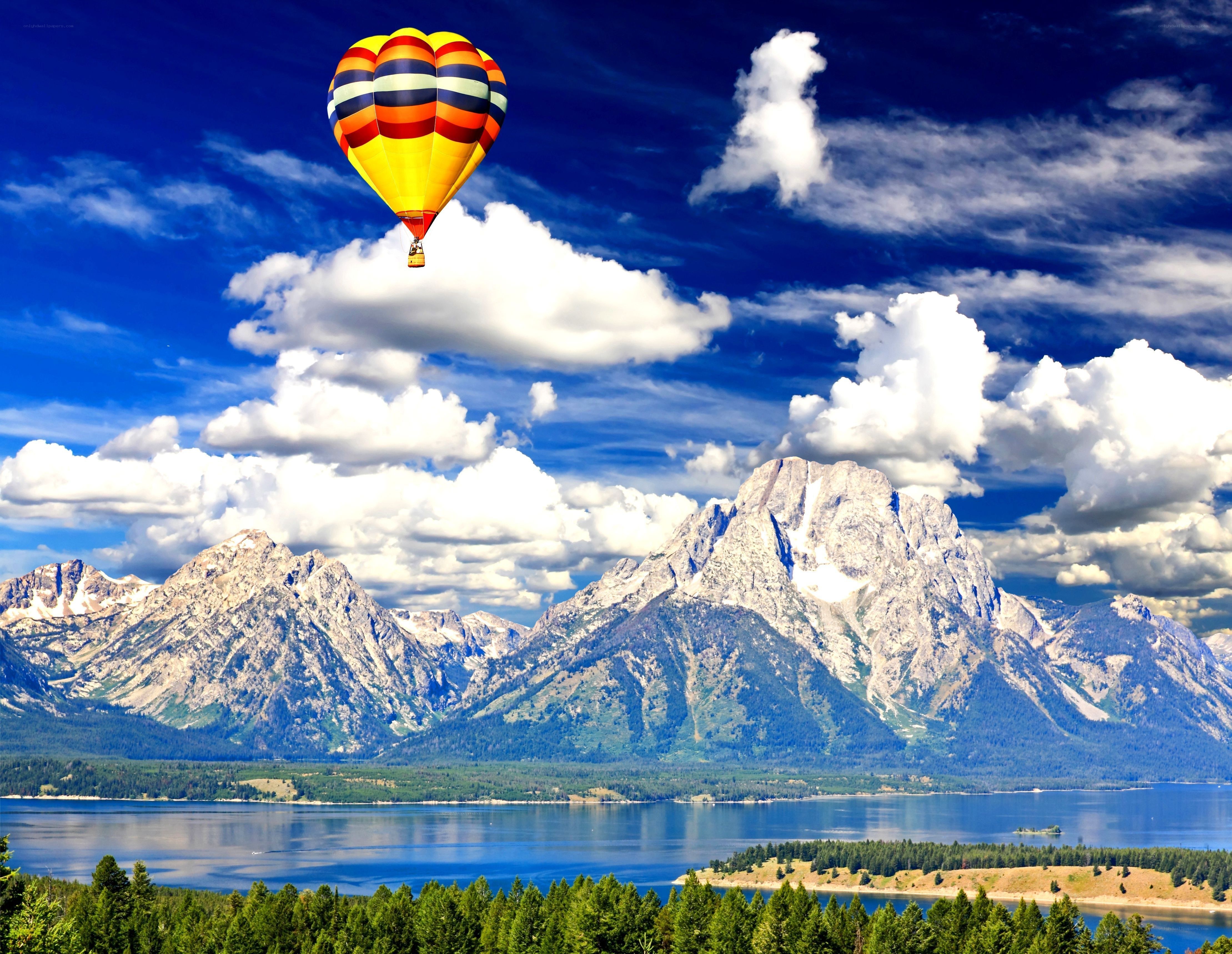 Hot air balloon over mountain lake