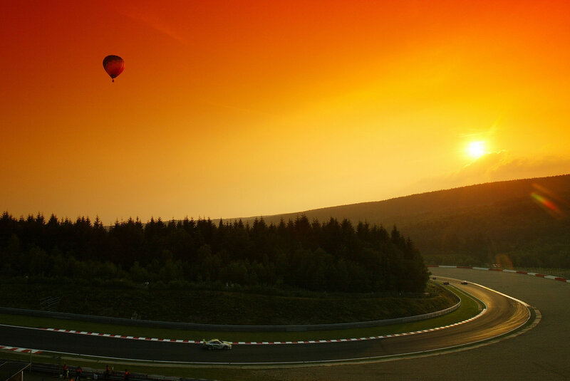Hot air balloon over racetrack at sunset