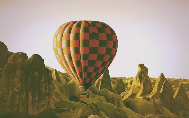 Hot Air Balloon over Rocks — Orange, Serene