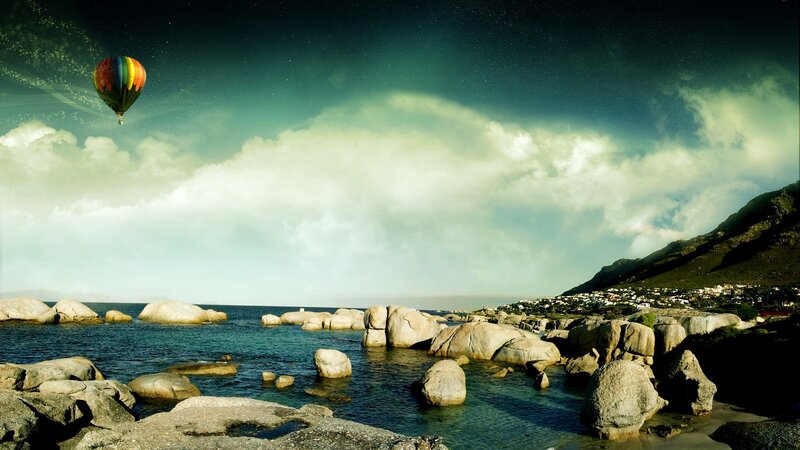 Hot air balloon over rocky coast
