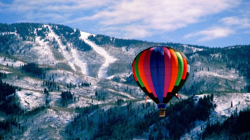 Hot air balloon over snowy mountains
