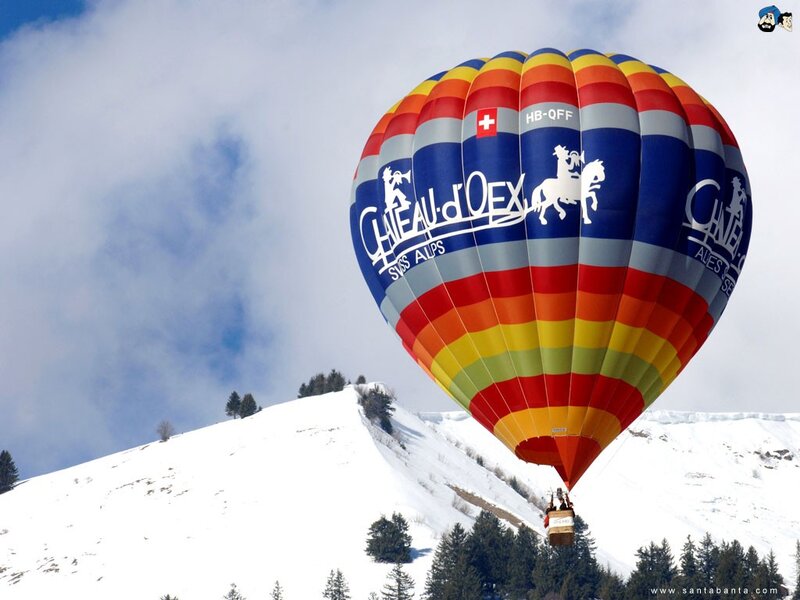 Hot air balloon over snowy mountains