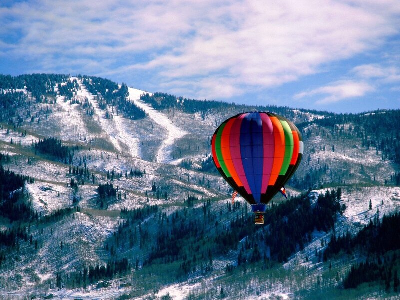 Hot air balloon over snowy mountains