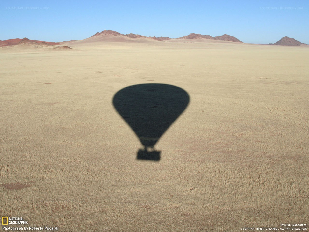 Hot air balloon shadow in desert