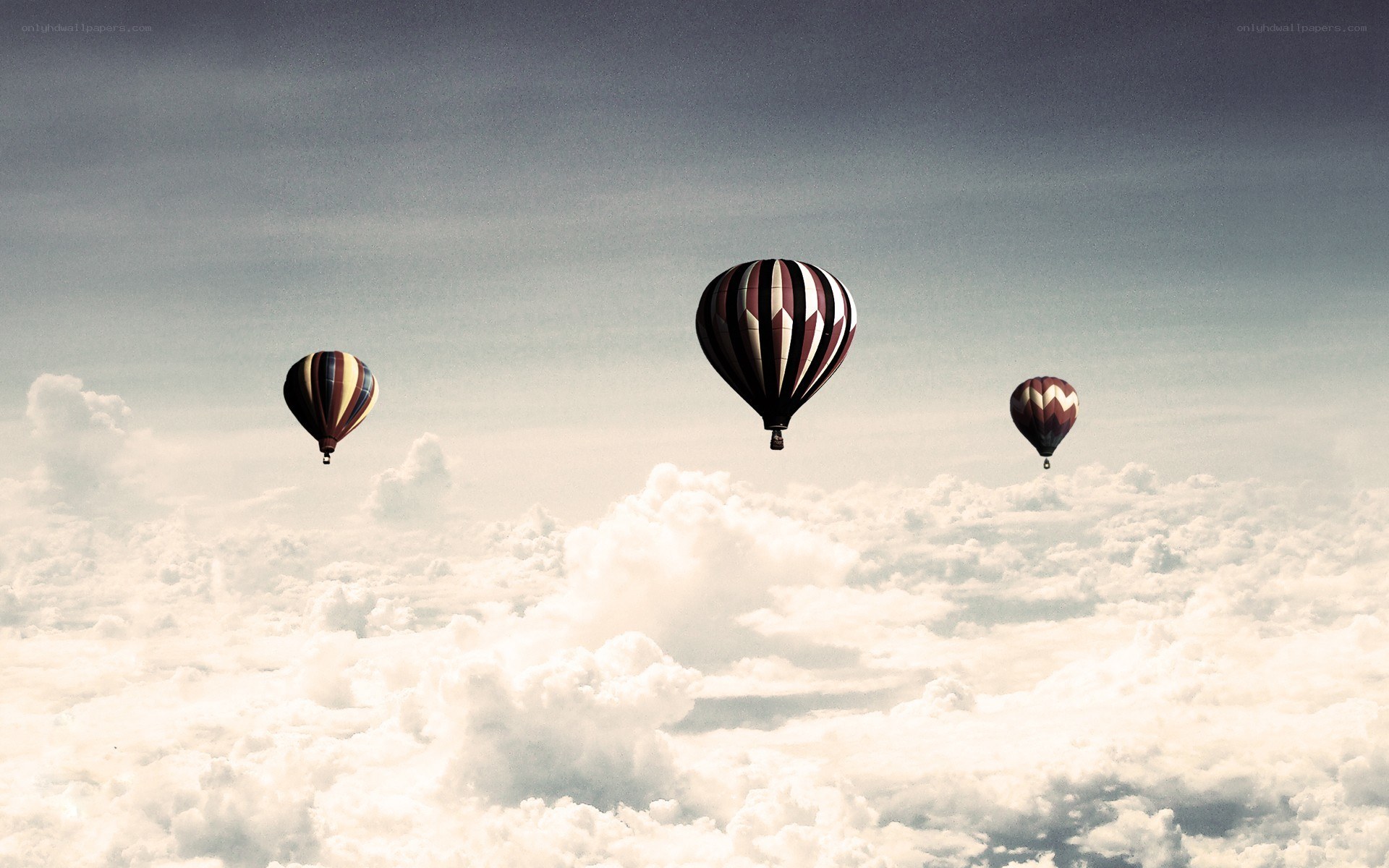 Hot air balloons above clouds