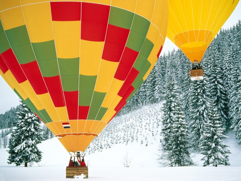Hot air balloons in snowy forest