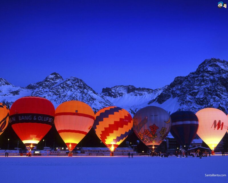 Hot air balloons in snowy mountains