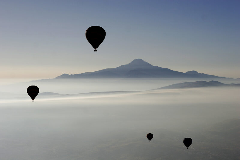 Hot air balloons over foggy mountains