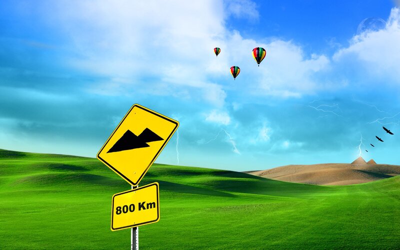 Hot air balloons over green hills